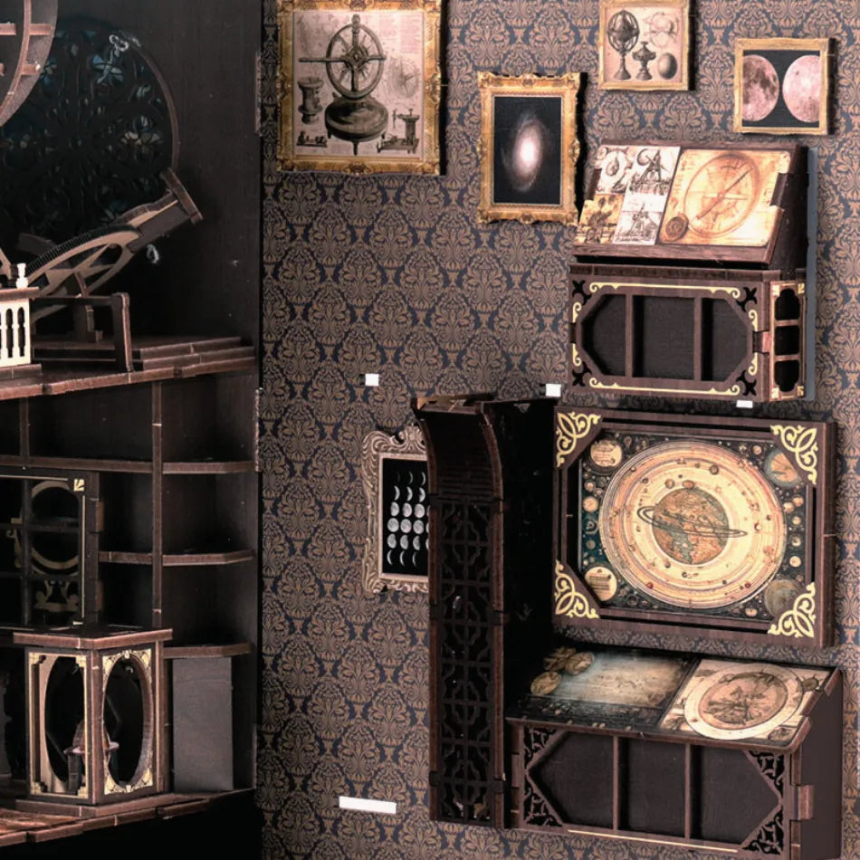 Decorative wall with vintage-style frames and a detailed clock on a patterned wallpaper.