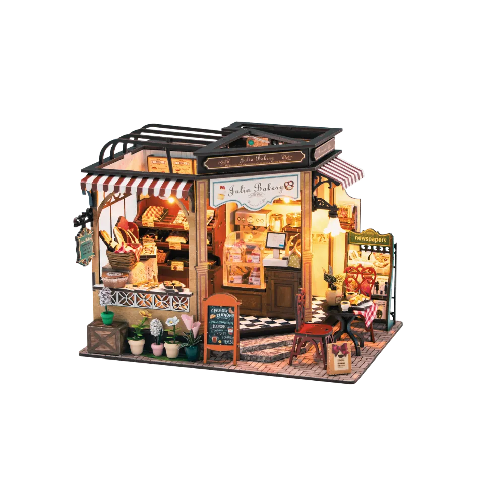 Model of a bakery shop with illuminated interior on a white background