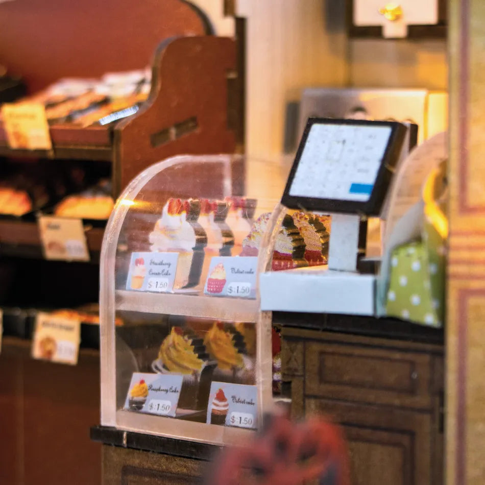 Display case with cakes and a cash register in a bakery setting
