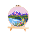 Embroidery hoop with a scenic landscape design on a white background
