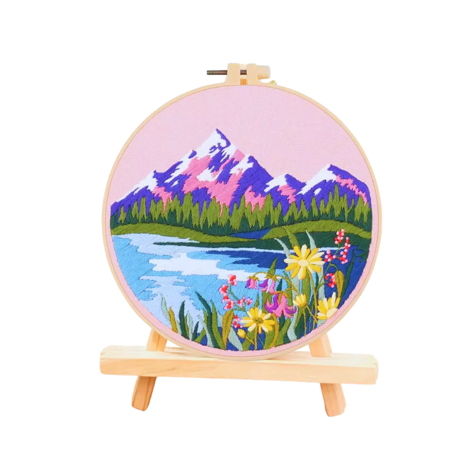 Embroidery hoop with a scenic landscape design on a white background