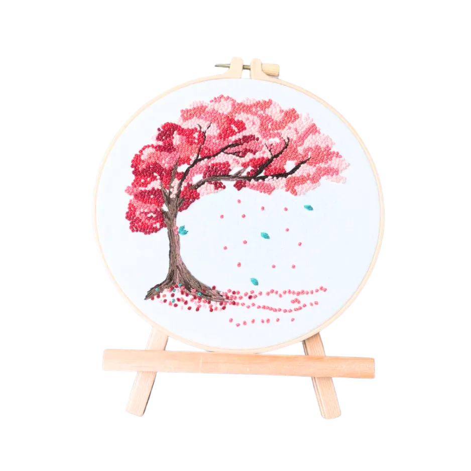Embroidery hoop with cherry blossom tree design on a white background