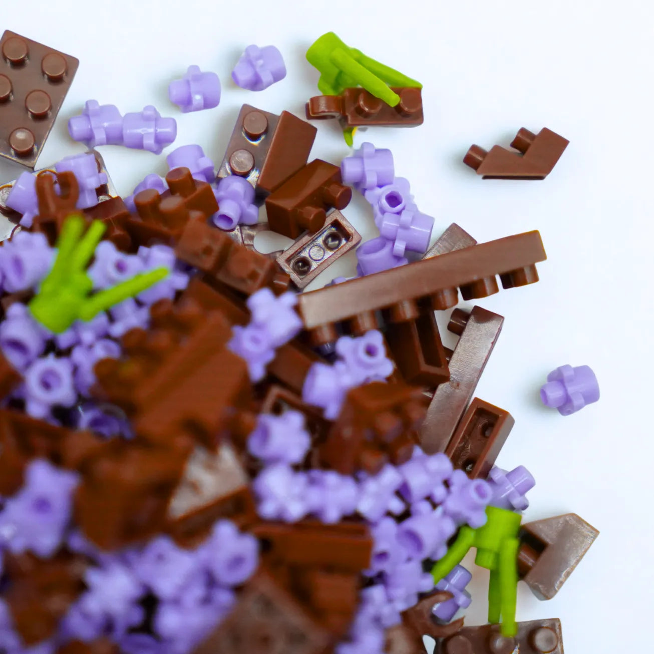Pile of brown, purple, and green toy building blocks on a white background