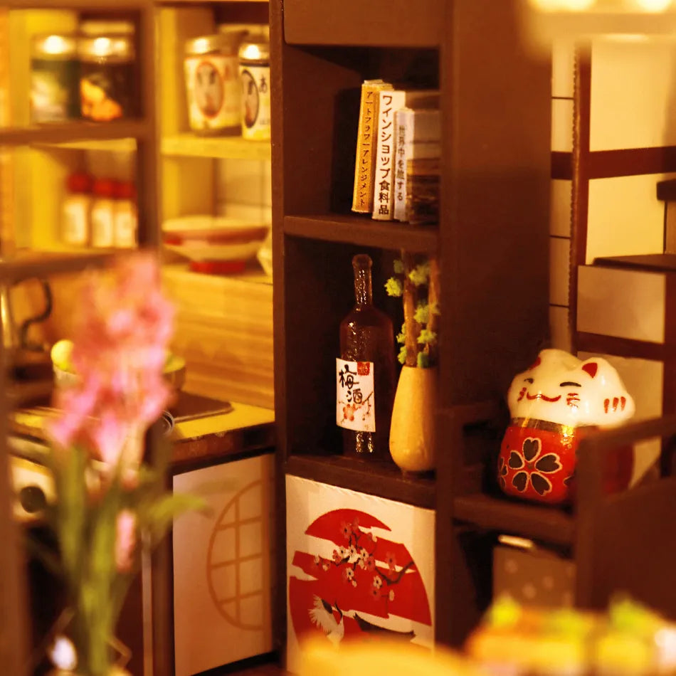 Shelf with various items including a bottle, books, and a decorative cat figurine in a warm-lit room.