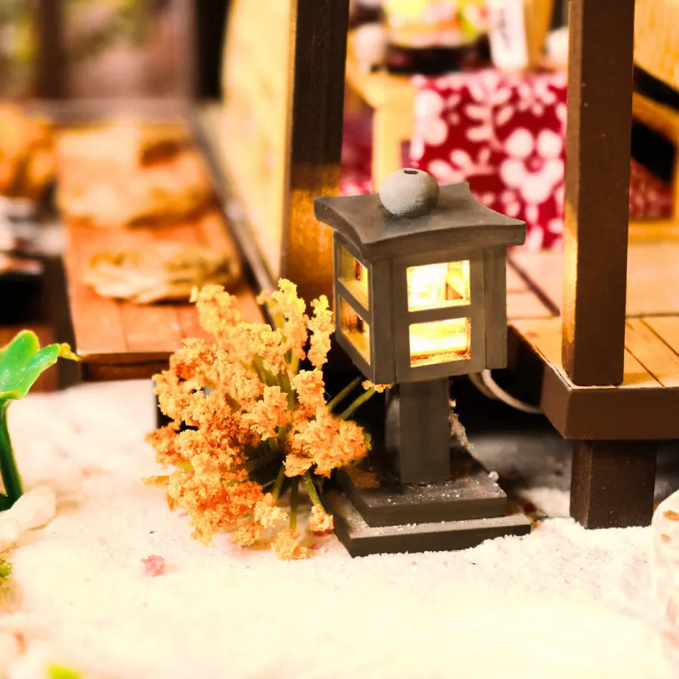 Decorative lantern with glowing light on a small table with flowers and blurred background