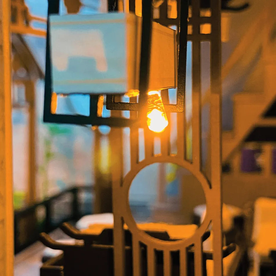 Close-up of a light bulb inside a decorative metal frame with a blurred background