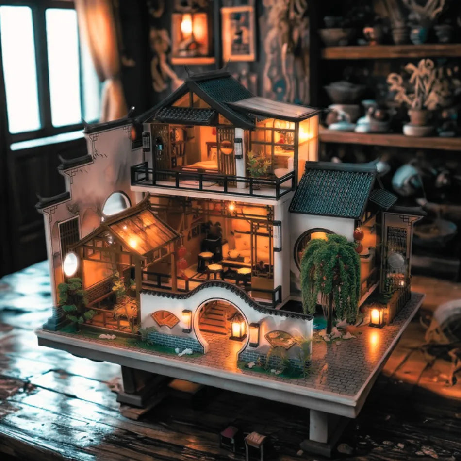 Detailed model of a traditional Chinese house with illuminated interior, placed on a wooden surface.