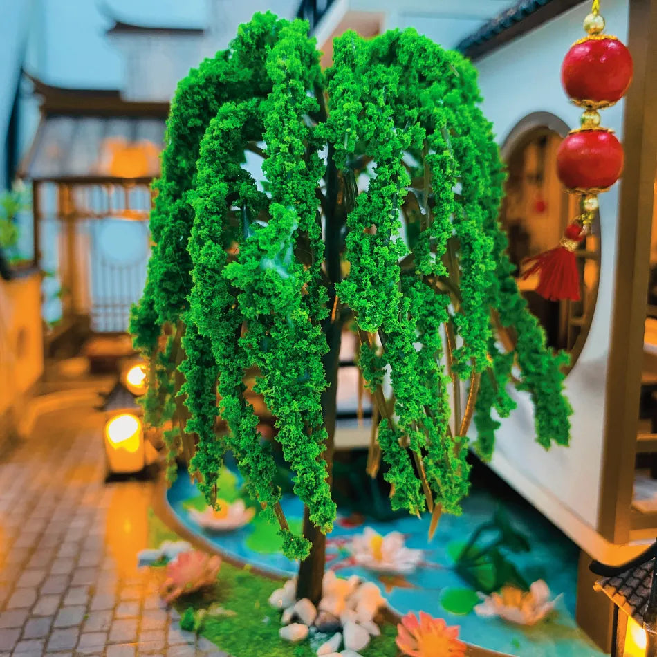 Decorative green tree with hanging ornaments in a miniature garden setting