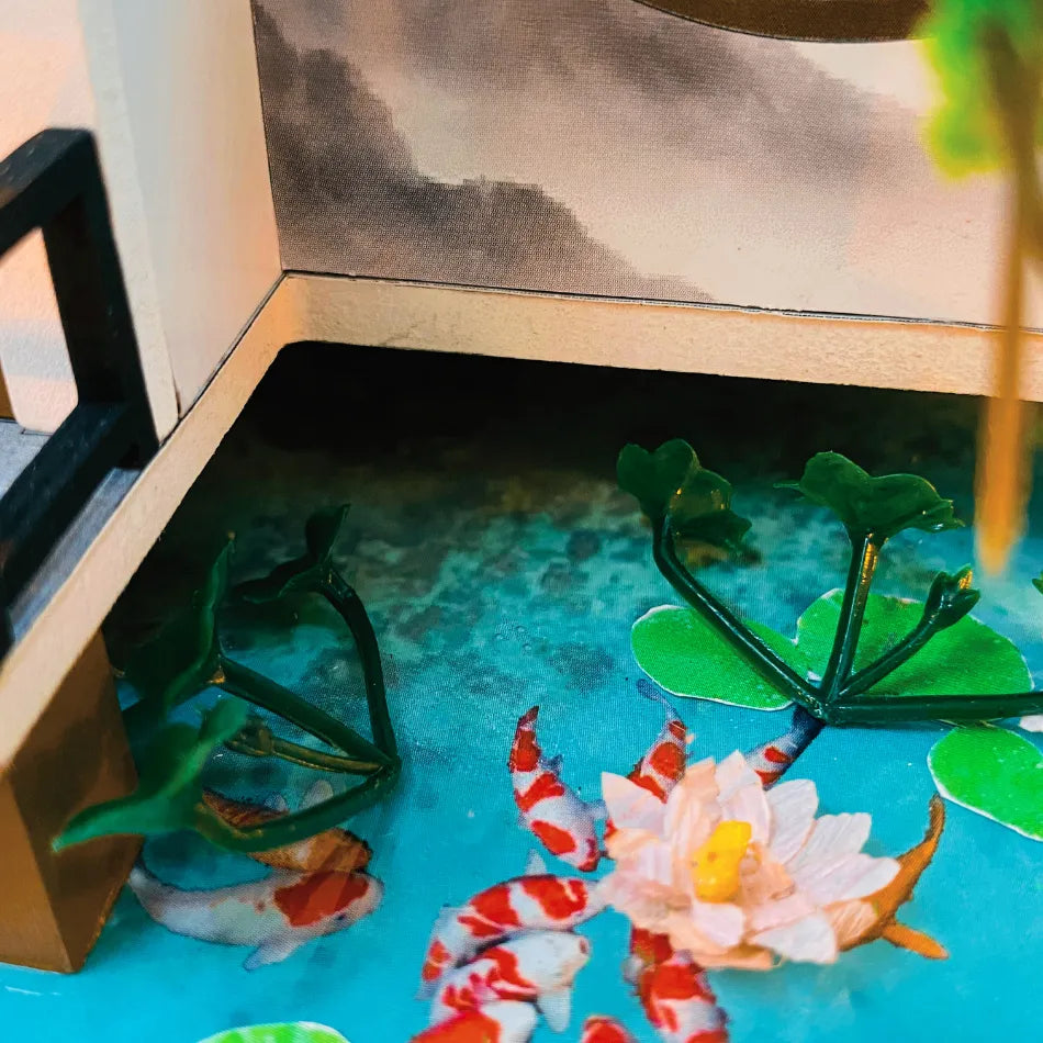 Model pond with fish and lily pads on a wooden base