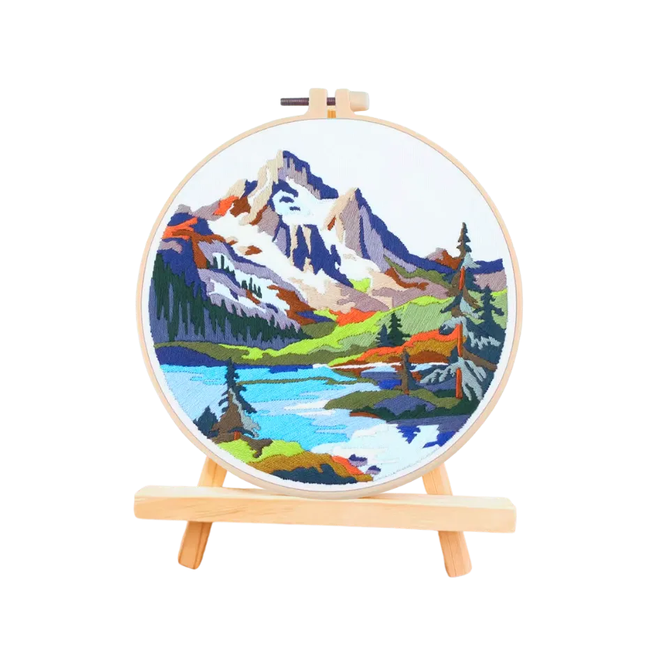 Embroidery hoop with a mountain landscape design on a white background