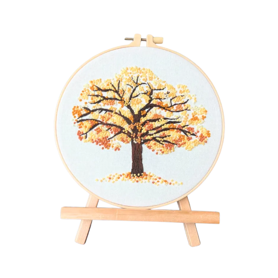 Embroidery hoop with a tree design on a white background