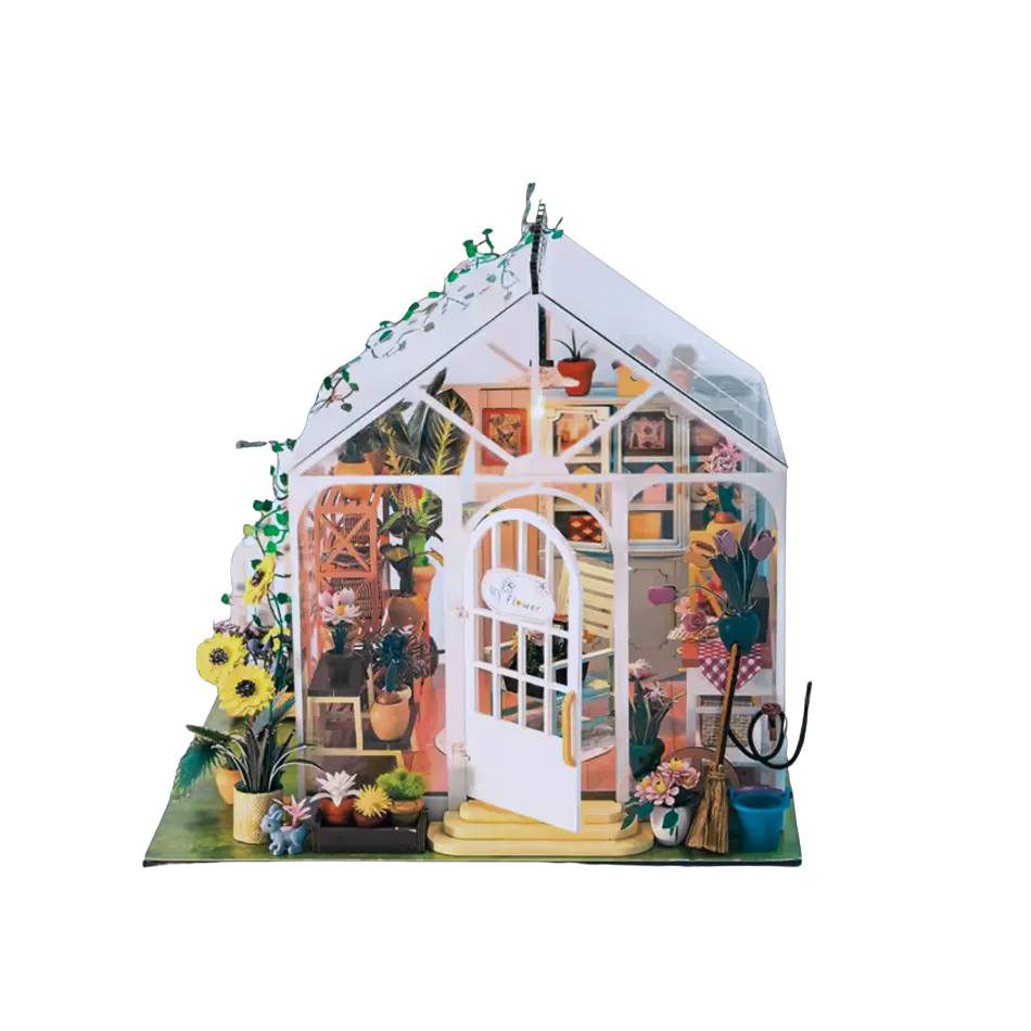 Miniature model of a greenhouse with plants and decor on a white background