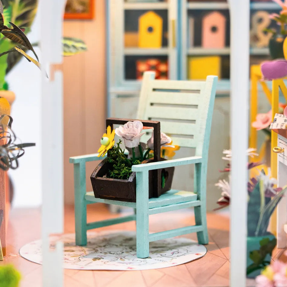 Small turquoise chair with a plant on a colorful background