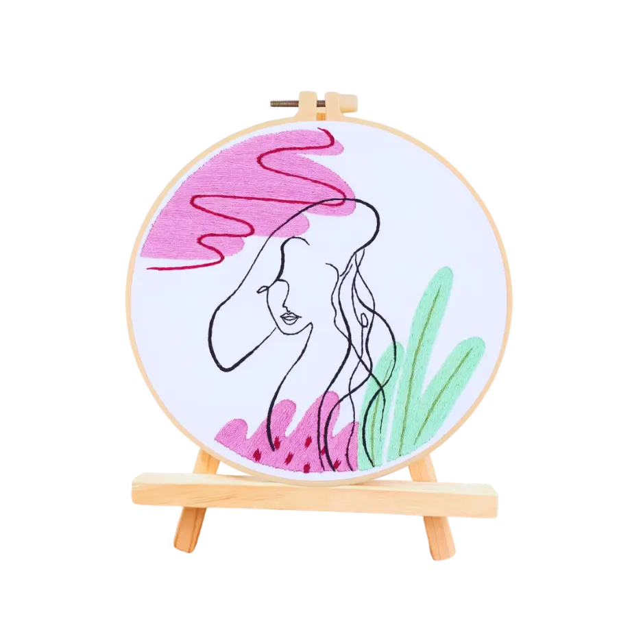 Embroidery hoop with a woman's face design on a white background