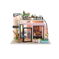 Model of a small music store with plants and furniture on a white background