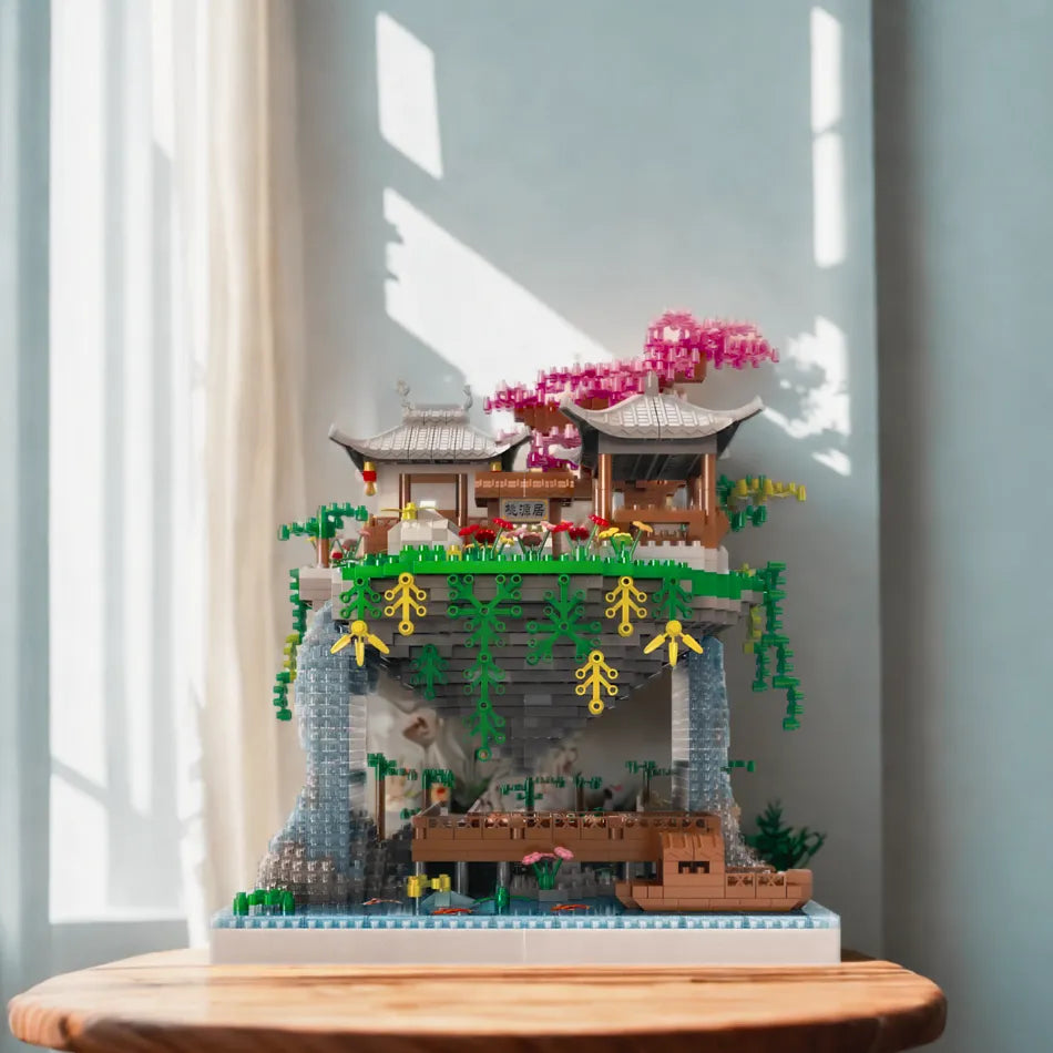 Detailed building blocks of a mountain village with a pagoda on a wooden surface.
