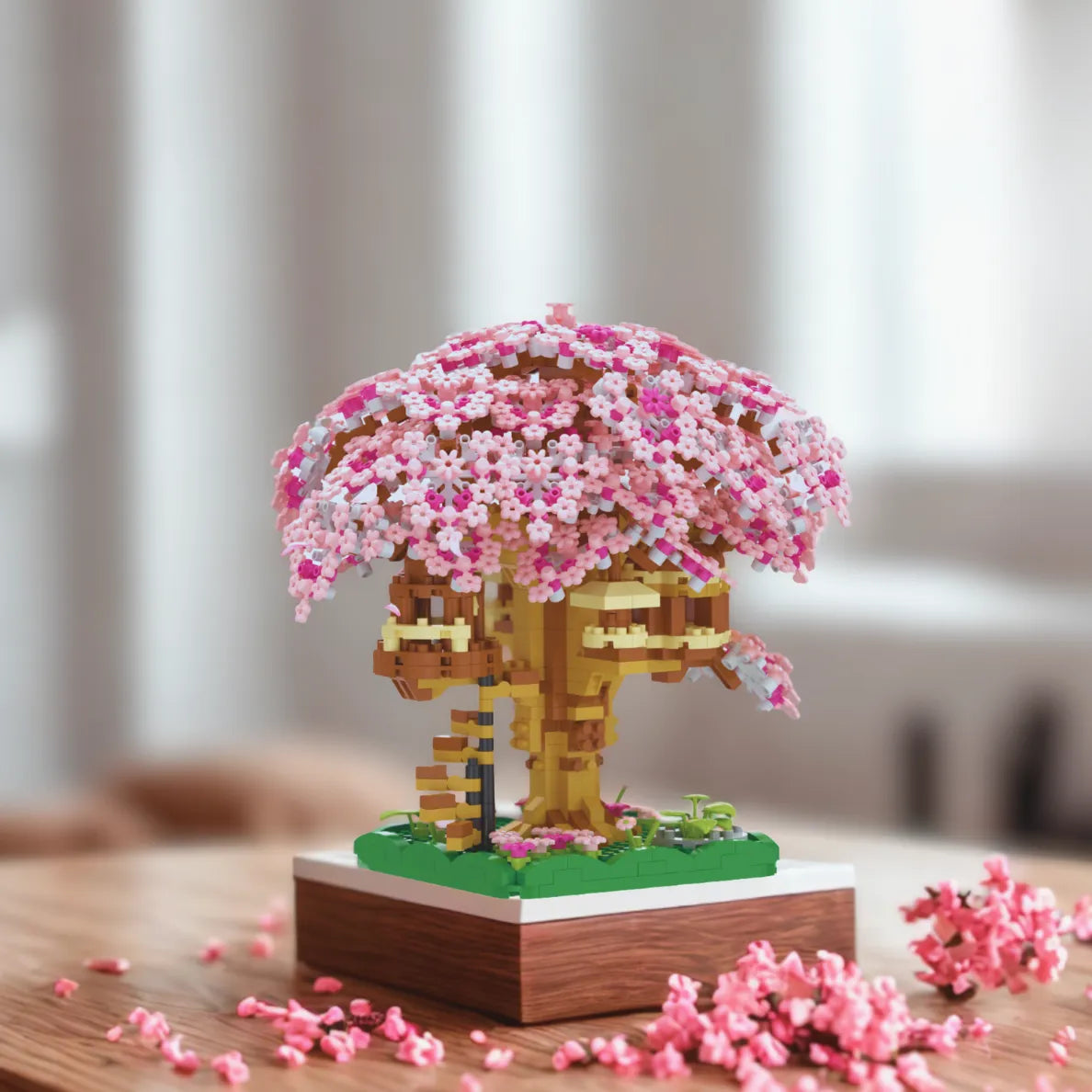 Toy model of a cherry blossom tree with pink flowers on a wooden base.