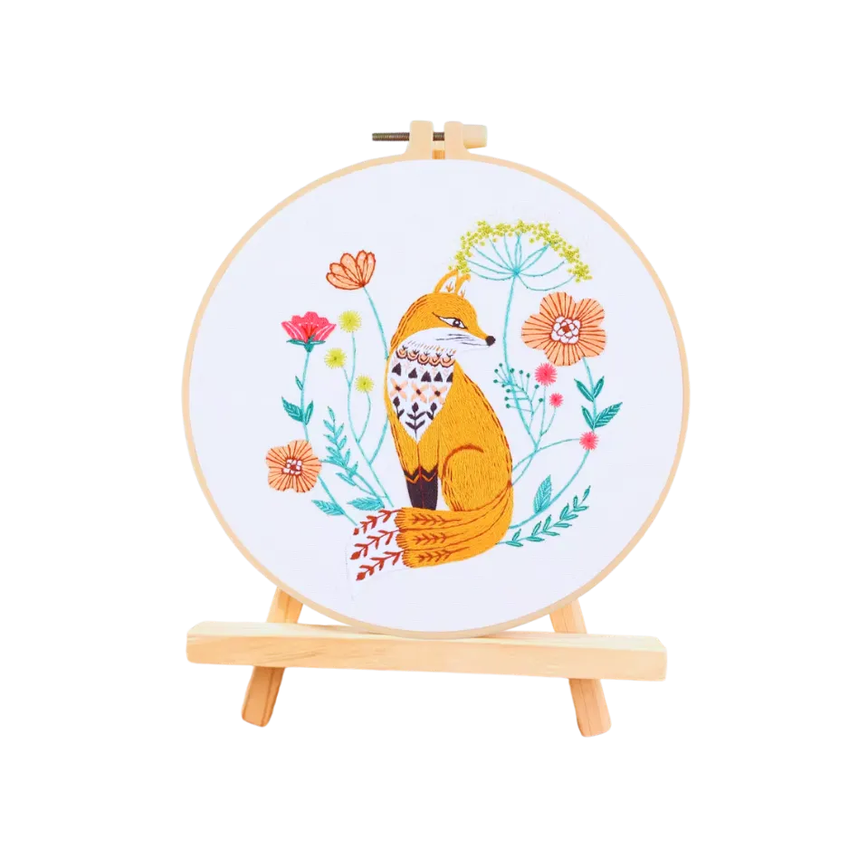 Embroidery hoop with a fox and floral design on a white background