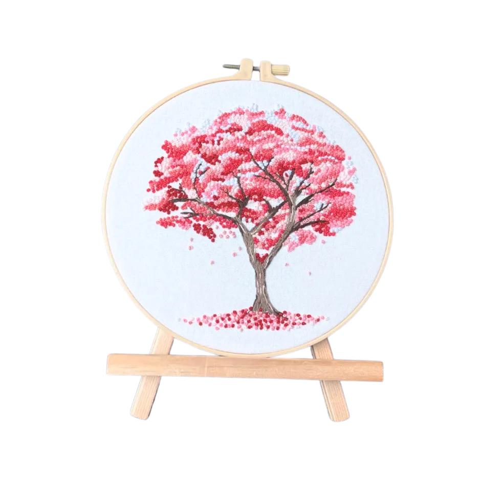 Cross-stitched tree with pink leaves on a white background