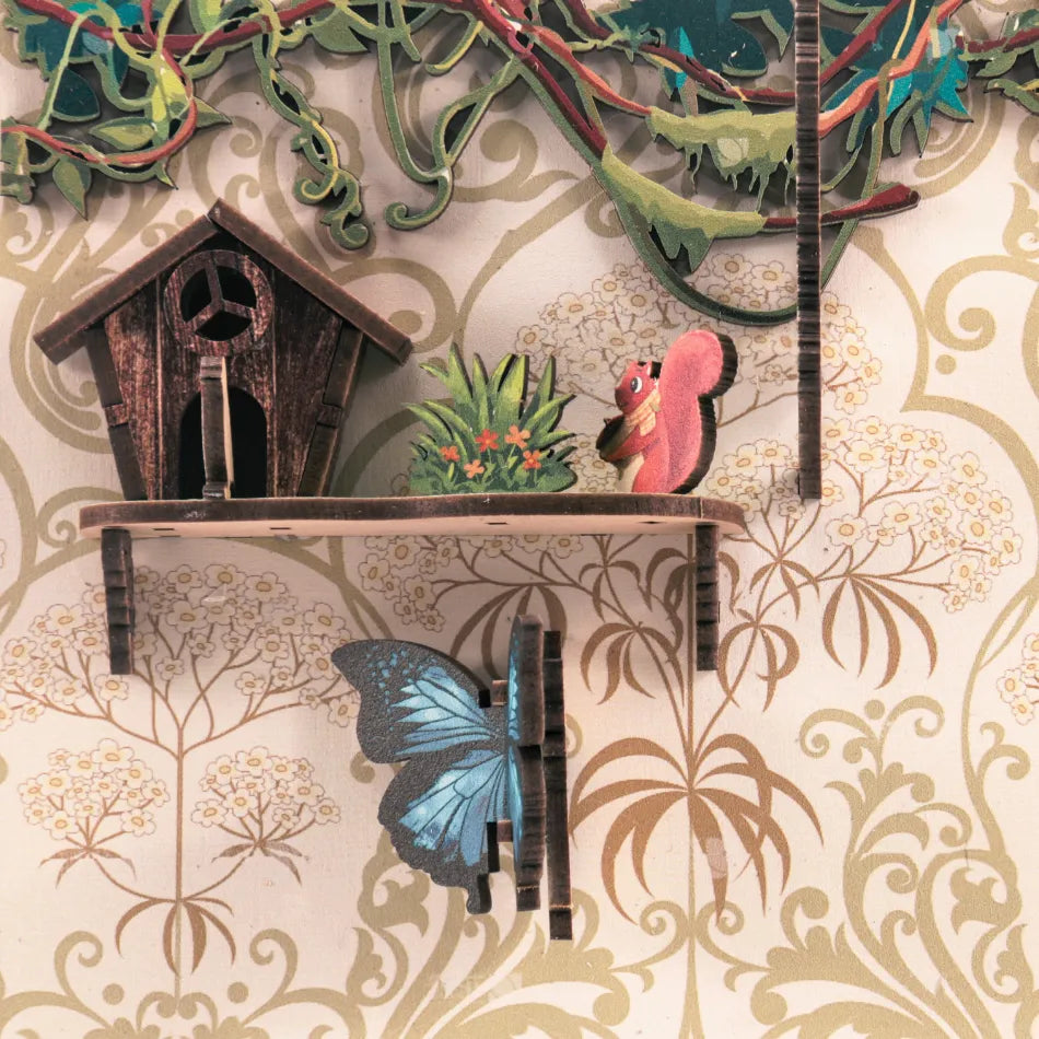 Decorative wall piece with birdhouse, plants, and butterfly on a floral wallpaper background
