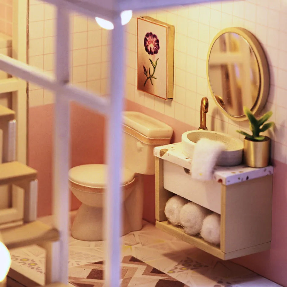 Small bathroom with pink walls, white toilet, sink, and decorative elements.