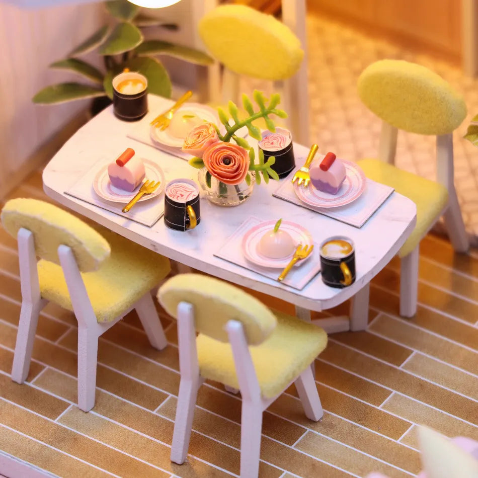 Children's table and chairs set with miniature food items on a tiled floor.
