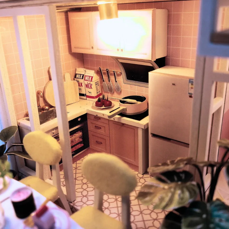 Small kitchen with pink walls, white appliances, and various items on the counter.
