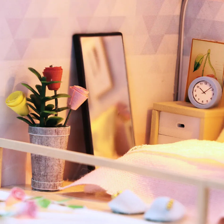 Small potted plant with colorful flowers on a shelf next to a clock and mirror.