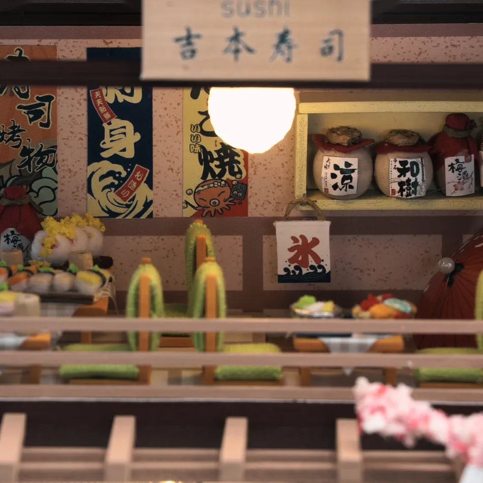 Miniature sushi bar with various sushi items and condiments on a wooden counter.