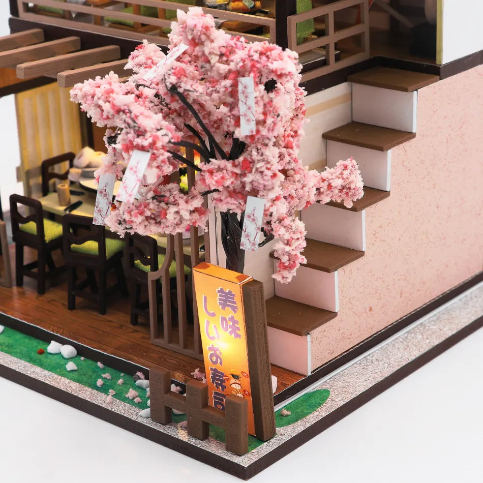 Model of a restaurant interior with cherry blossom tree and signboard
