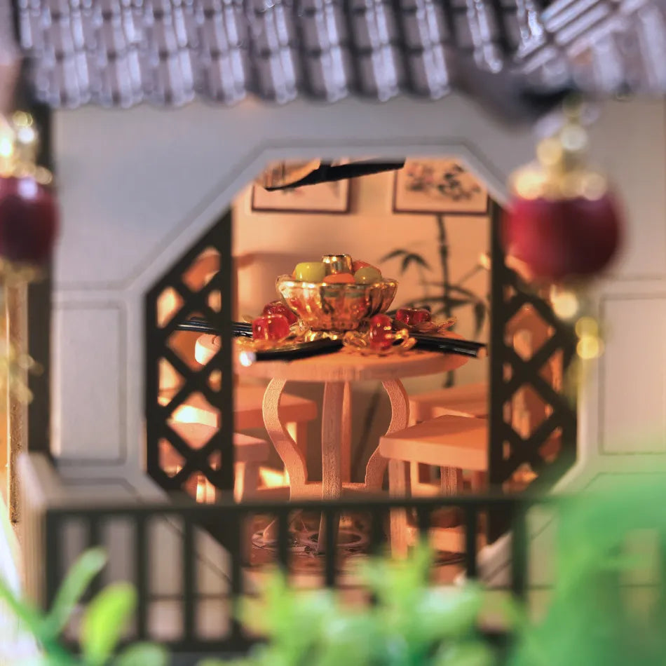 Miniature dining scene with a table and chairs through decorative lattice