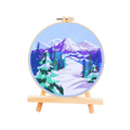 Embroidery hoop with a winter landscape design on a white background