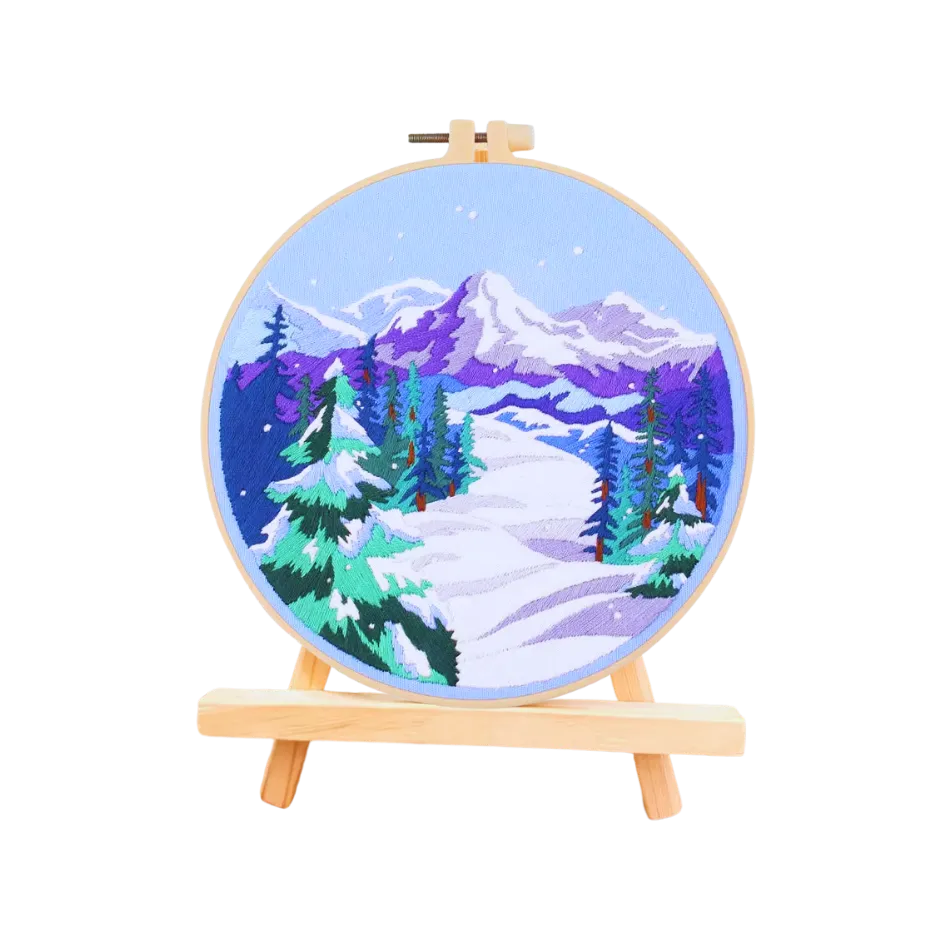 Embroidery hoop with a winter landscape design on a white background