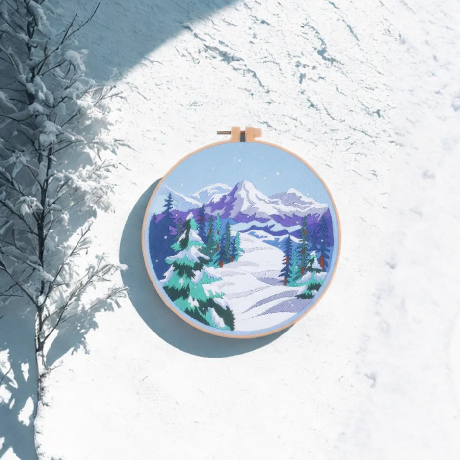 Embroidery hoop with a winter landscape design in a snowy setting