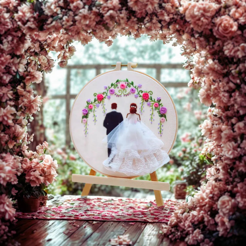 Embroidery hoop with a wedding couple design surrounded by pink flowers