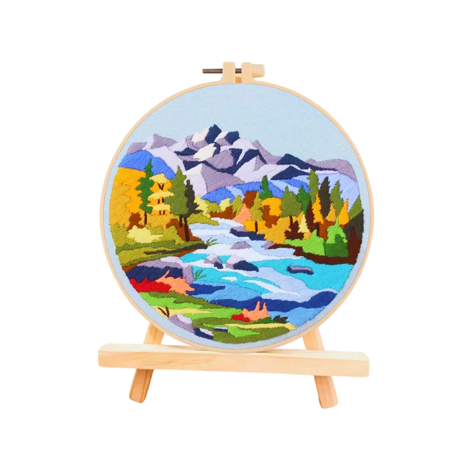 Embroidery hoop with a mountain landscape design on a white background
