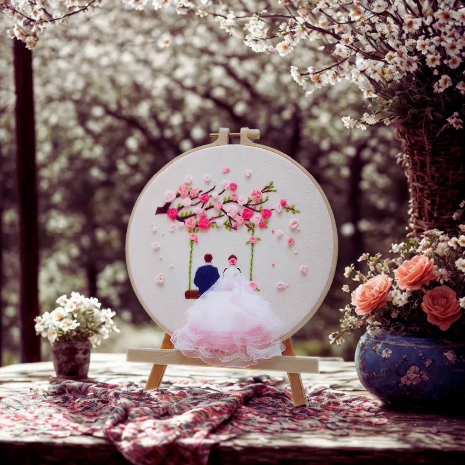 Embroidery hoop with floral design and birds, set against a blurred floral background