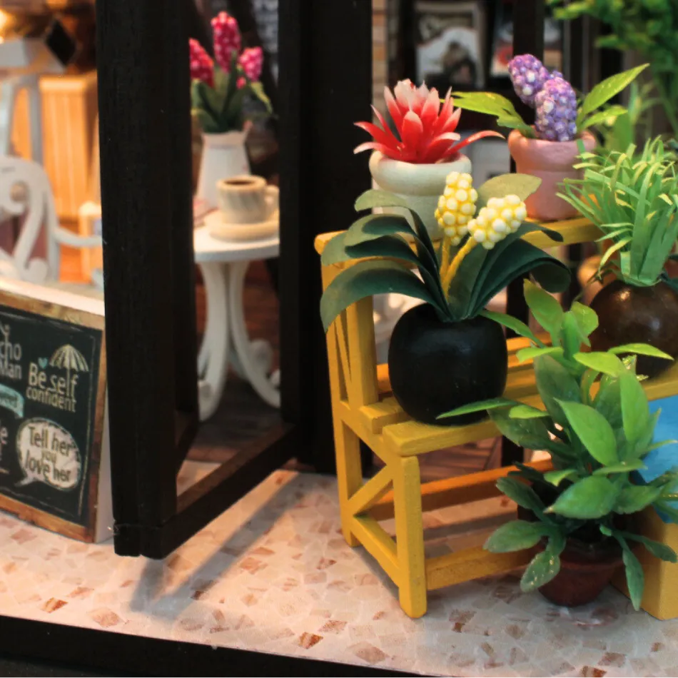 Miniature potted plants on a small wooden stool with a blurred background